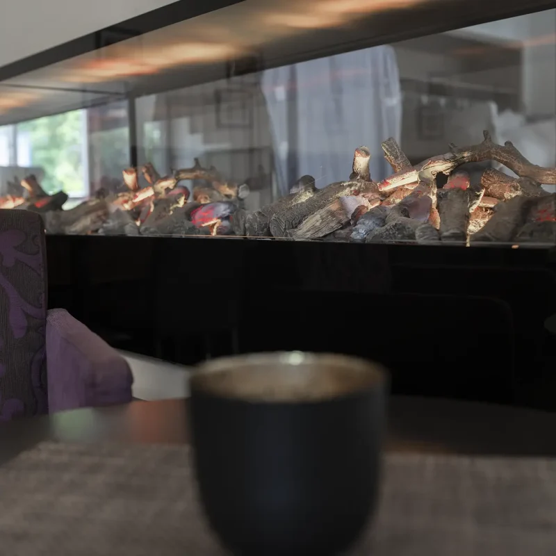 Lange gedeckte Restauranttafel mit weißen gefalteten Servietten und gepolsterten Stühlen.